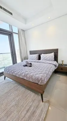 a bedroom with a bed with a large window at Luxury 2BR Midtown Apartment in Dubai