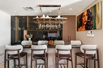 a dining room with a bar with chairs and a painting at Luxury Apartment at Dubai Creek Harbour, Bayshore - By DuStay in Dubai