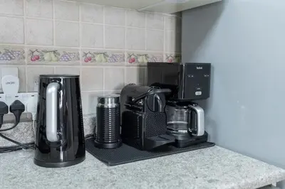 a kitchen counter with a coffee maker and a coffeemaker at StayShort - Cozy 1-Bedroom Apartment for 5 in Motor City! in Dubai