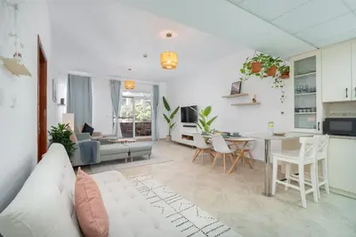 a living room with a couch and a table at StayShort - Cozy 1-Bedroom Apartment for 5 in Motor City! in Dubai