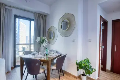 a dining room with a table and chairs and mirrors at The Smart Concierge - Bahar 6 in Dubai