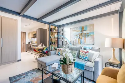 a living room with a couch and a table at Modern Loft-Style Studio at Aria Residence, Jumeirah Village Circle by Deluxe Holiday Homes in Dubai