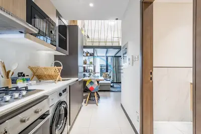 a kitchen with a washer and dryer in a room at Modern Loft-Style Studio at Aria Residence, Jumeirah Village Circle by Deluxe Holiday Homes in Dubai