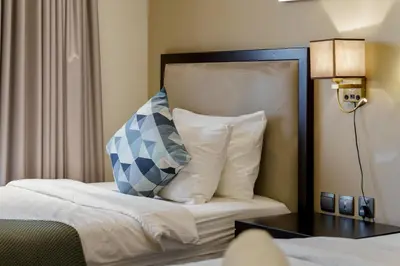 a hotel room with a bed with a blue and white pillow at Cozy 2BR in Elite Downtown Residence with Canal view in Dubai