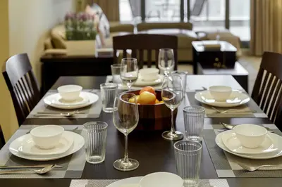 a table with glasses and a bowl of fruit on it at Cozy 2BR in Elite Downtown Residence with Canal view in Dubai