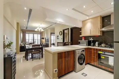a kitchen and living room with a dining room at Cozy 2BR in Elite Downtown Residence with Canal view in Dubai