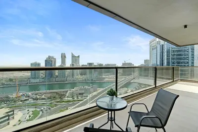 a balcony with a table and chairs and a view of the city at Cozy 2BR in Elite Downtown Residence with Canal view in Dubai