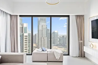 a white living room with a large window at Peaceful Dunes 2 - Near Burj Khalifa & Dubai Mall in Dubai