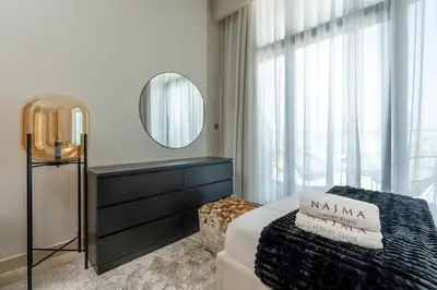 a bedroom with a bed and a dresser and a mirror at Nasma Luxury Stays - Azizi Riviera 6 Cozy Studio with Burj Khalifa View in Dubai