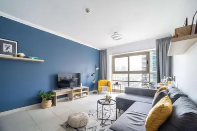 a blue living room with a couch and a tv at Frank Porter - Marina Quays West Tower in Dubai