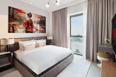 a bedroom with a bed and a large painting on the wall at Elegant 2-Bedroom Apartment in Dubai Creek Harbour - By Dustay in Dubai