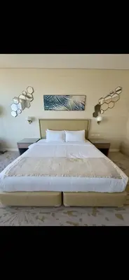 a bedroom with a large white bed with two pillows at Gorgeous Palm View in Dubai