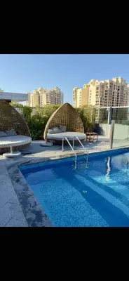 two umbrellas and a swimming pool in a city at Gorgeous Palm View in Dubai