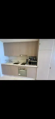 a kitchen with white cabinets and a stove top oven at Gorgeous Palm View in Dubai