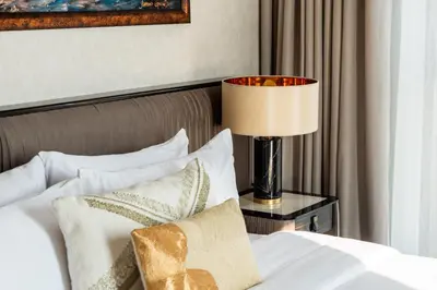 a bedroom with a bed with a lamp on a table at Family Friendly luxurious Waterfront Apartment - By Dustay in Dubai