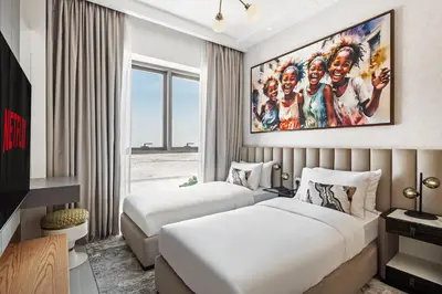 two beds in a hotel room with a painting on the wall at Family Friendly luxurious Waterfront Apartment - By Dustay in Dubai