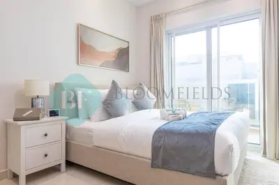 a bedroom with a bed and a large window at Bloomfields Cozy Studio In Hera Tower Dubai in Dubai