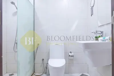 a bathroom with a shower and a toilet and a sink at Bloomfields Cozy Studio In Hera Tower Dubai in Dubai