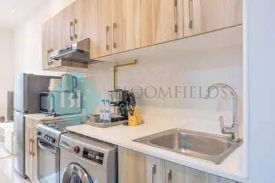 a kitchen with a sink and a dishwasher at Bloomfields Cozy Studio In Hera Tower Dubai in Dubai