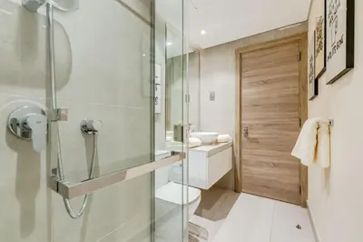 a bathroom with a shower and a toilet and a sink at Knokey Dubai Marina Comfortable Apartments with Pool and Gym in Dubai