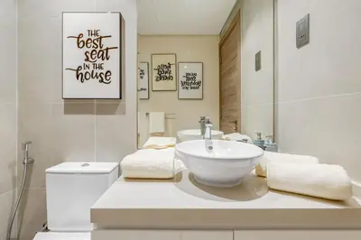 a bathroom with a sink and a toilet and a mirror at Knokey Dubai Marina Comfortable Apartments with Pool and Gym in Dubai