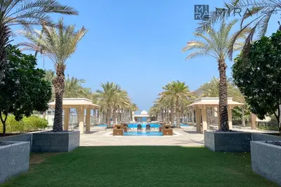 a park with palm trees and a swimming pool at Mira Holiday Homes - Spacious 2 bedroom with patio in Palm Jumeirah in Dubai
