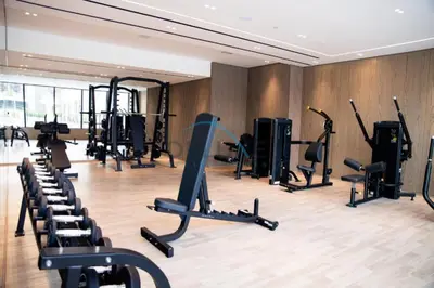 a gym with treadmills and exercise equipment in a room at Cozy 1BR at Binghatti Corner, Jumeirah Village Circle by Deluxe Holiday Homes in Dubai