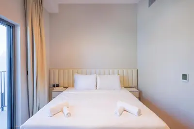 a bedroom with a bed with two towels on it at Mag Eye Townhouse - 2BR & M Room Townhouse - Allsopp & Allsopp in Dubai