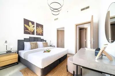 a bedroom with a large bed and a desk at Frank Porter - Parkside Rawda 4 in Dubai