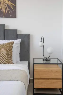 a bedroom with a bed and a table with a lamp at Frank Porter - Parkside Rawda 4 in Dubai