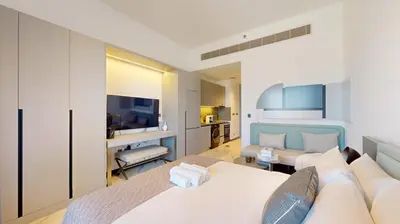 a bedroom with a bed and a living room at Mag Eye 910 - Tranquil Studio Apartment in Meydan in Dubai