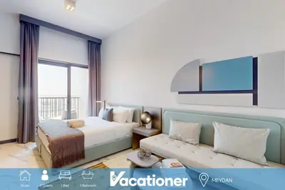 a hotel room with a bed and a couch at Mag Eye 910 - Bright Studio Apartment in Meydan in Dubai