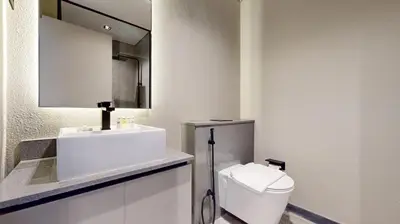 a white bathroom with a toilet and a sink at Mag Eye 910 - Bright Studio Apartment in Meydan in Dubai