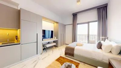 a hotel room with a bed and a television at Mag Eye 910 - Bright Studio Apartment in Meydan in Dubai