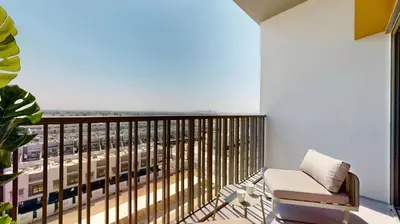 a balcony with a chair and a train at Mag Eye 910 - Bright Studio Apartment in Meydan in Dubai