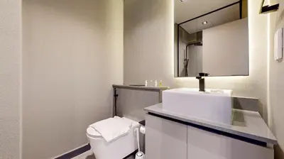 a bathroom with a toilet and a sink and a mirror at Mag Eye 920 - Classy Studio Apartment in Meydan in Dubai