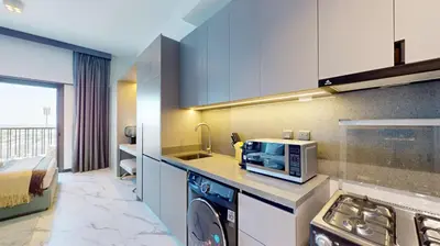 a kitchen with a microwave oven and a stove at Mag Eye 920 - Classy Studio Apartment in Meydan in Dubai