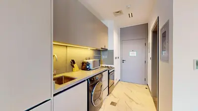 a kitchen with a sink and a dishwasher at Mag Eye 920 - Classy Studio Apartment in Meydan in Dubai