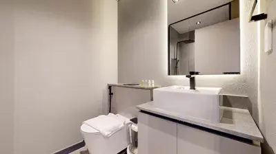 a white bathroom with a toilet and a sink at Mag Eye 890 - Modern Studio Apartment in Meydan in Dubai