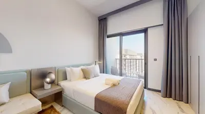 a bedroom with a bed and a large window at Mag Eye 890 - Modern Studio Apartment in Meydan in Dubai