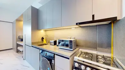 a kitchen with a washing machine and a microwave at Vacationer I Stylish Studio I Skyline & Community Views I 12 Mins to Downtown I MAG Eye 910 in Dubai