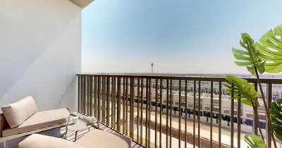 a balcony with two chairs and a view of a building at Vacationer I Stylish Studio I Skyline & Community Views I 12 Mins to Downtown I MAG Eye 910 in Dubai