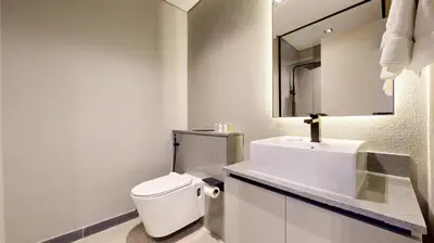 a white bathroom with a toilet and a sink at Mag Eye 910 - Peaceful Studio Apartment in Meydan in Dubai