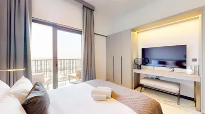 a hotel room with a bed and a television at Mag Eye 910 - Peaceful Studio Apartment in Meydan in Dubai