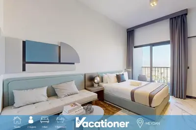 a hotel room with a bed and a couch at Mag Eye 930 - Calm Studio Apartment in Meydan in Dubai