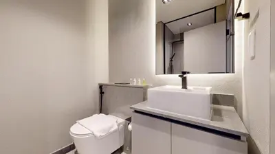a bathroom with a toilet and a sink and a mirror at Mag Eye 930 - Calm Studio Apartment in Meydan in Dubai