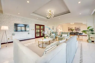 a living room with a couch and a table at Prestigious 5BR Villa with Assistant Room and Private Pool in Frond O Palm Jumeirah by Deluxe Holiday Homes in Dubai