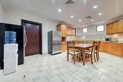 a kitchen with a table and a refrigerator at Prestigious 5BR Villa with Assistant Room and Private Pool in Frond O Palm Jumeirah by Deluxe Holiday Homes in Dubai