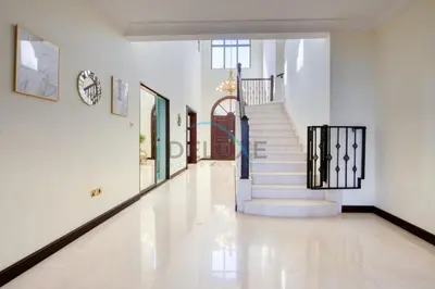 a hallway with a staircase with white walls and white floors at Prestigious 5BR Villa with Assistant Room and Private Pool in Frond O Palm Jumeirah by Deluxe Holiday Homes in Dubai