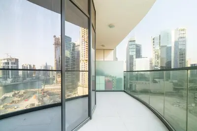 an empty room with glass windows in a building at Citihome - 1BR with Huge Balcony & Easy Transport Access in Dubai